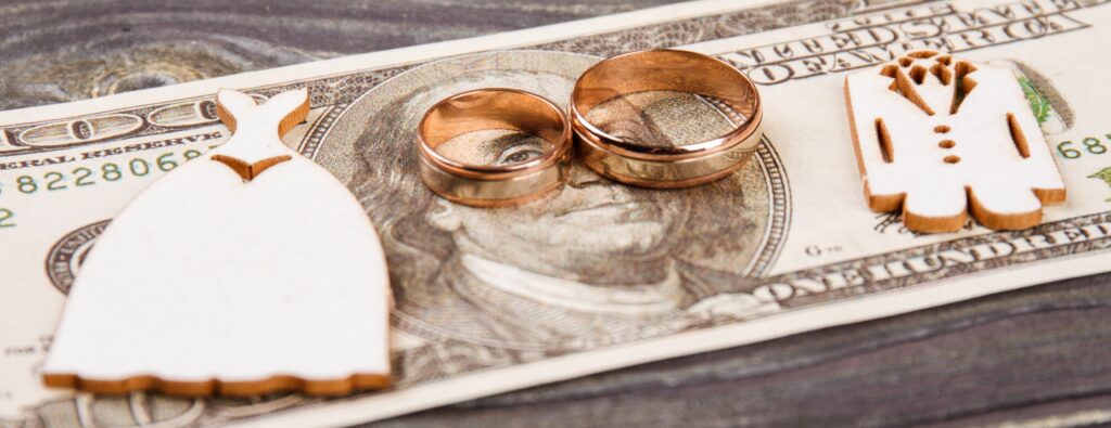 Wedding rings on the 100 dollars bills. Wedding expenses concept.